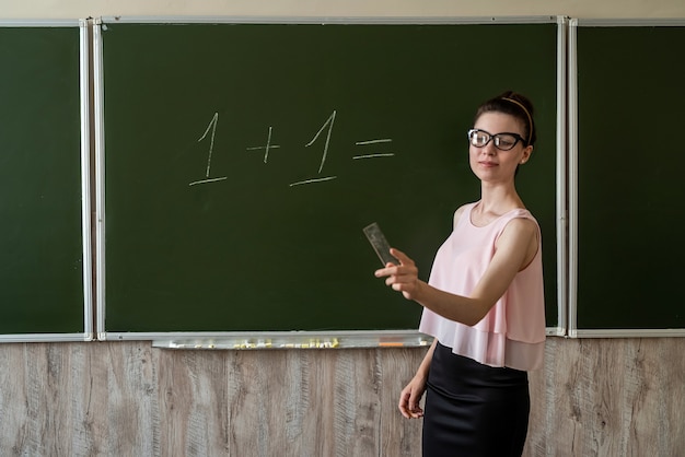 Grundschullehrer, der auf Tafel eins geschrieben wurde, füge eins hinzu. Grundschule