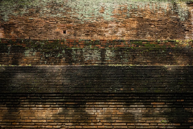 Grunge antigo da parede de tijolos sujo com musgo