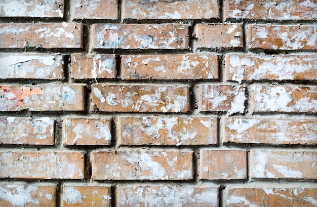 Grunge strukturierter Hintergrund der Backsteinmauer mit zerrissenen geklebten Papieren