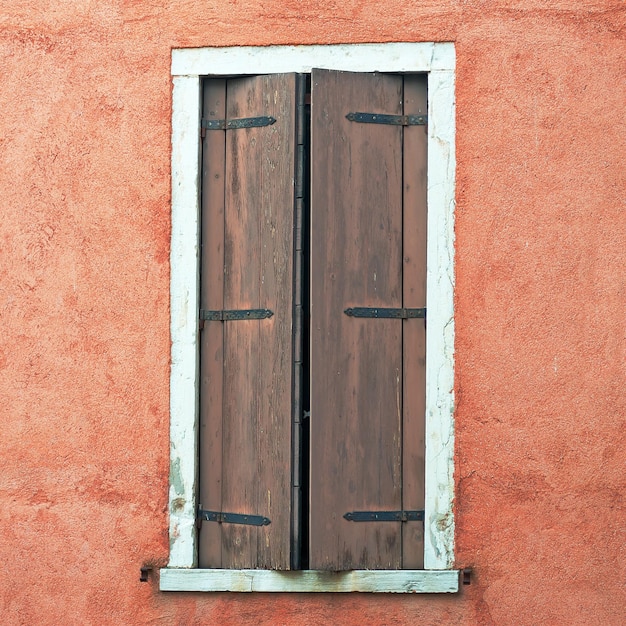 Grungy Fenster in einer roten Wand