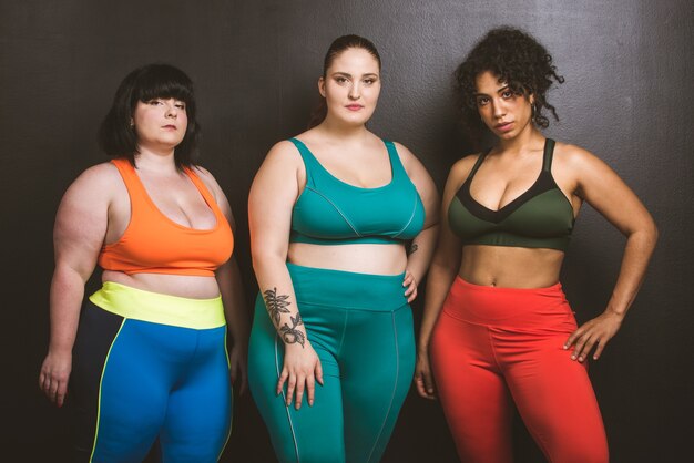 Grupo de 3 mujeres de gran tamaño posando. Aceptación corporal y positividad corporal