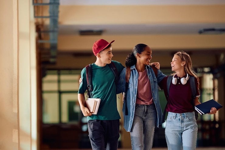 Foto un grupo de adolescentes felices caminando por el pasillo de la escuela secundaria.