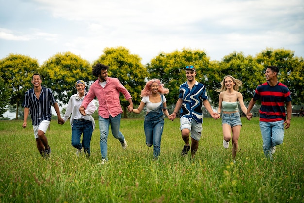 Grupo de adolescentes multiétnicos pasando tiempo al aire libre en un picnic en el parque