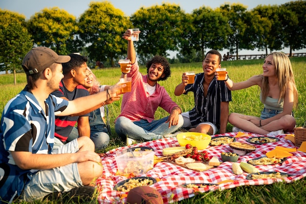 Foto grupo de adolescentes multiétnicos pasando tiempo al aire libre en un picnic en el parque