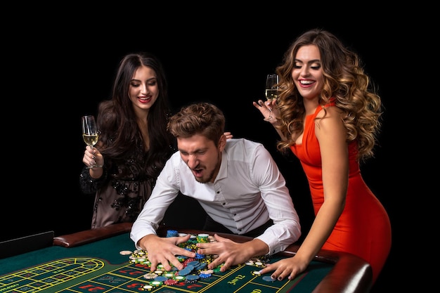 Grupo de adultos celebrando amigo ganando en la ruleta