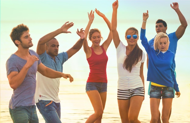 Grupo de adultos jóvenes de fiesta en la playa.