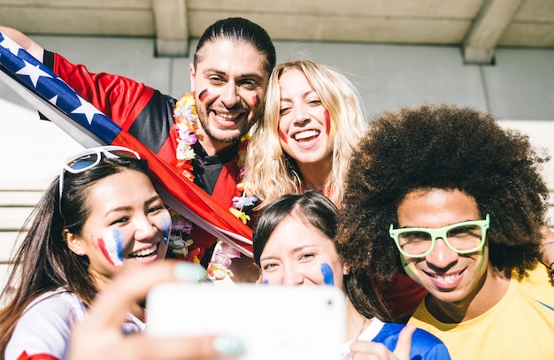 Grupo de aficionados al fútbol mixto tomando selfie