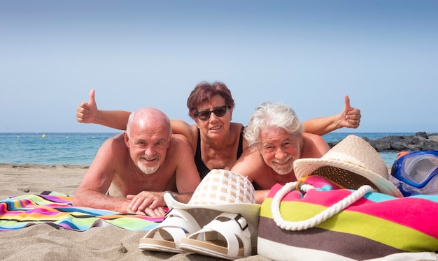 Grupo alegre de três amigos curtindo juntos as férias de verão na praia