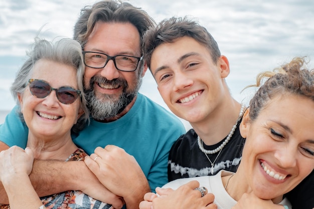 Un grupo alegre de madres e hijos, una familia multigeneracional, se divierten al aire libre junto al mar.