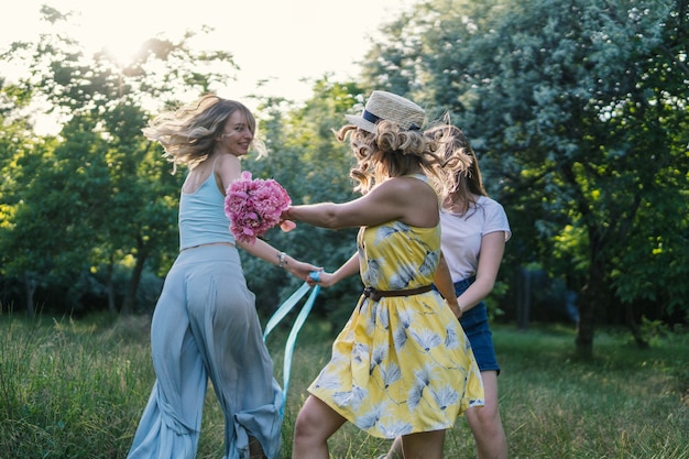 Grupo de amigas haciendo picnic al aire libre. Bailan entre ellos. despedida de soltera