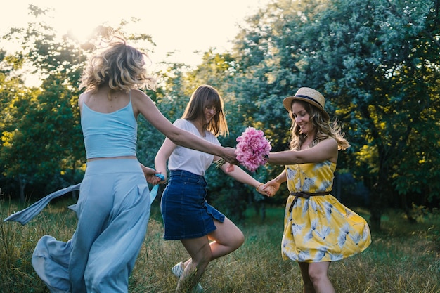 Grupo de amigas haciendo picnic al aire libre. Bailan entre ellos. despedida de soltera