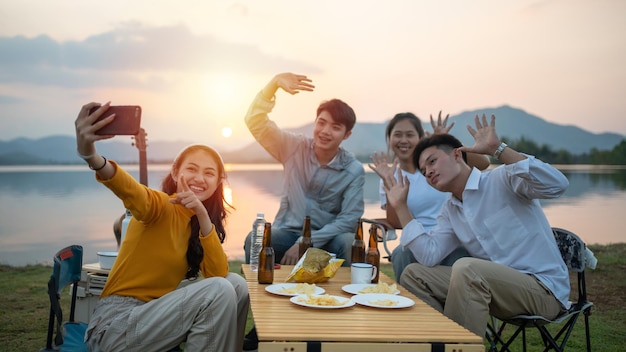 Grupo de amigos acampando juntos y usando selfie de teléfono inteligente mientras están de vacaciones