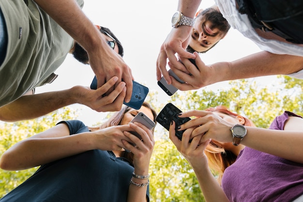 Foto grupo de amigos adultos de pie y mensajes de texto juntos