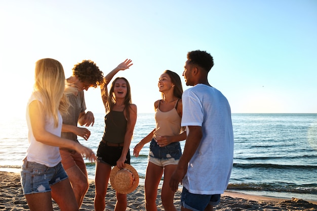 Grupo de amigos bailando música disco en la playa