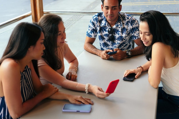 Grupo de amigos en un bar e interactuando con celulares