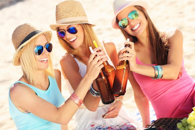 grupo de amigos, bebida, cerveza, en la playa