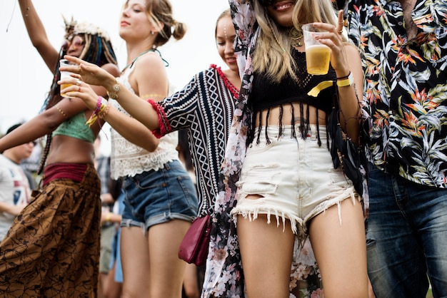 Grupo de amigos bebiendo cervezas disfrutando del festival de música juntos