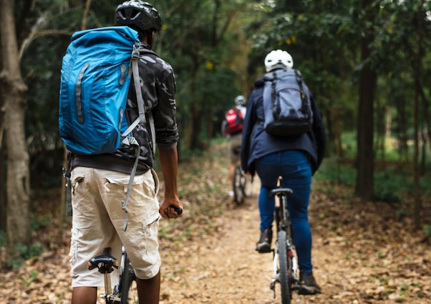 Grupo de amigos en bicicleta de montaña en el bosque juntos