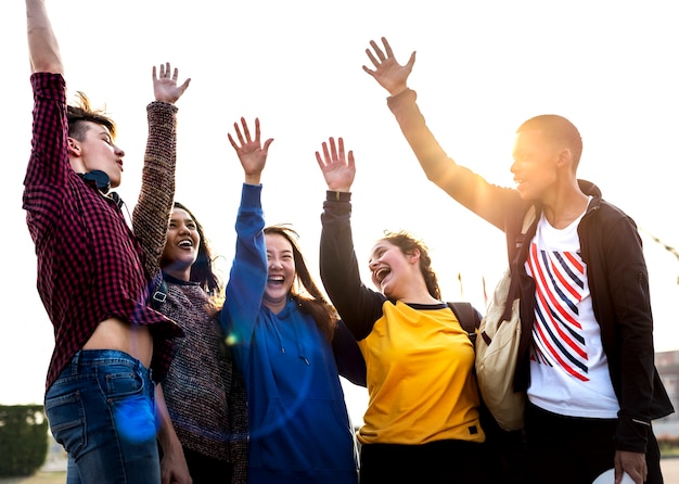 Grupo de amigos brazos levantados juntos concepto de apoyo y trabajo en equipo