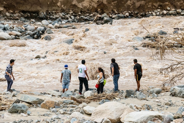 Un grupo de amigos caminando cerca de un río que fluye rápido