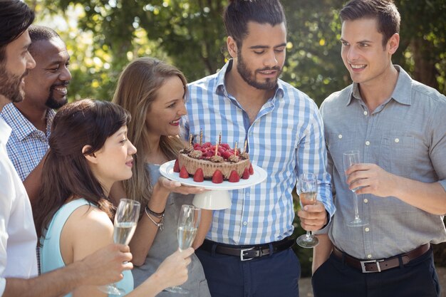 Grupo de amigos celebrando el cumpleaños de la mujer en el restaurante al aire libre