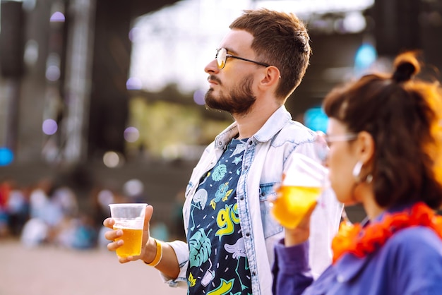 Grupo de amigos con cerveza bailando y divirtiéndose juntos en el festival de música Summer Beach party