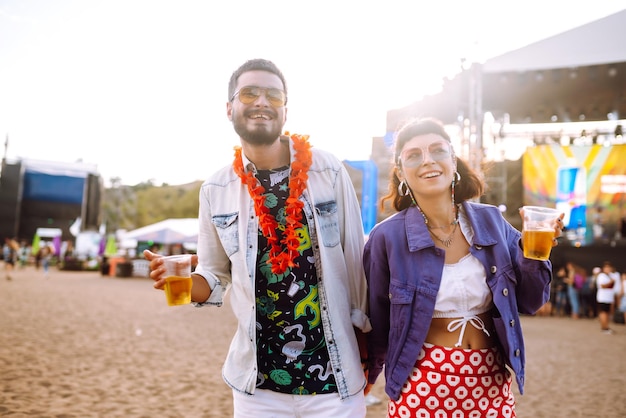 Grupo de amigos con cerveza bailando y divirtiéndose juntos en el festival de música Summer Beach party