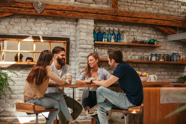 Grupo de amigos charlando y tomando café en casa