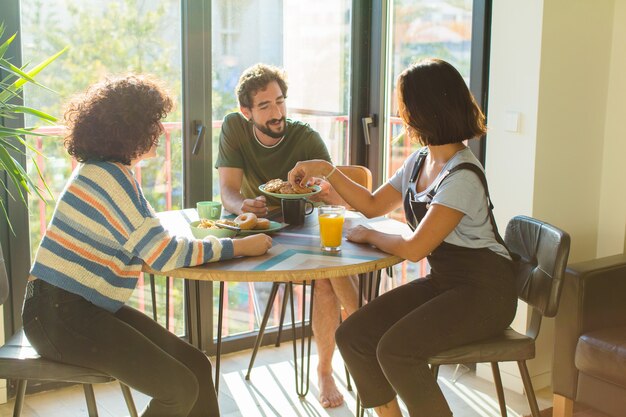 Grupo de amigos desayunando juntos en casa nueva