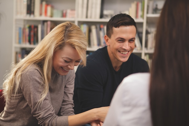 Grupo de amigos disfrutando de estudiar juntos en la biblioteca