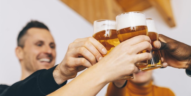 Foto grupo de amigos disfrutando de vasos de cerveza en la cervecería pub inglés jóvenes animando en el bar restaurante concepto de amistad y juventud
