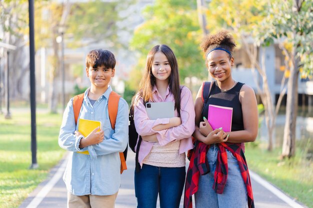 Grupo de amigos diversos en el campus de la escuela divirtiéndose