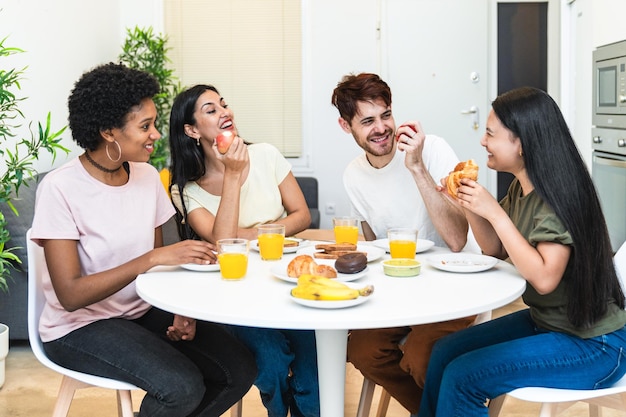 Foto un grupo de amigos diversos disfrutando de un desayuno lleno de risas y buena comida en un día soleado