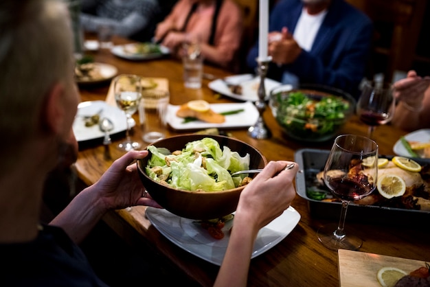 Grupo de amigos diversos están cenando juntos