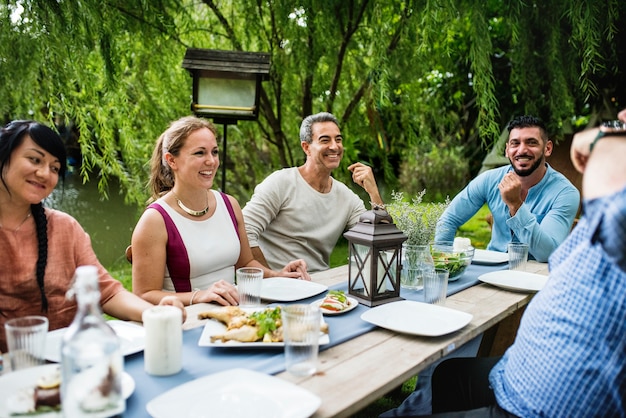 Grupo de amigos diversos están cenando juntos