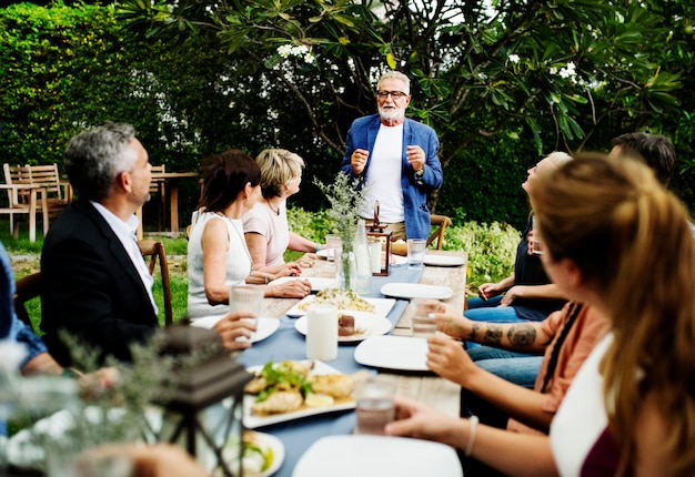 Grupo de amigos diversos están cenando juntos