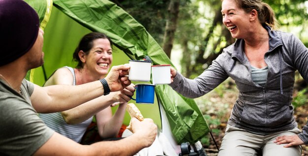 Grupo de amigos diversos que acampan en el bosque