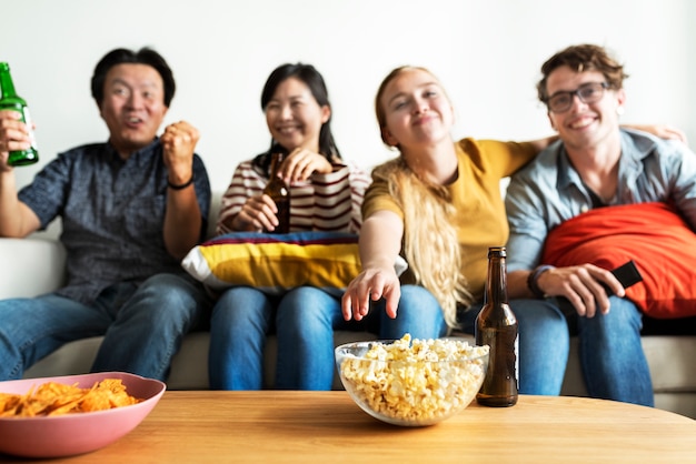 Grupo de amigos diversos que tienen una noche de película bebiendo cerveza