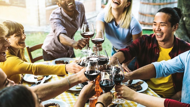 Grupo de amigos divirtiéndose en la cena de barbacoa en el restaurante del jardín