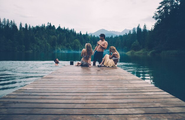 Grupo de amigos divirtiéndose en el lago por la mañana