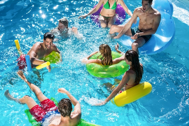 Grupo de amigos divirtiéndose en la piscina