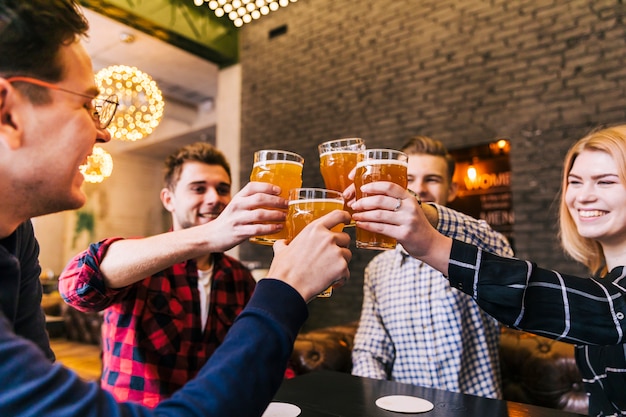 Grupo de amigos felices animando con vasos de cerveza