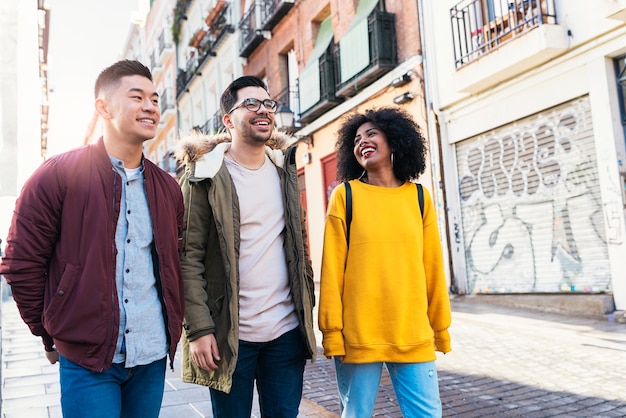 Grupo de amigos felices caminando por la calle. Concepto de amistad.