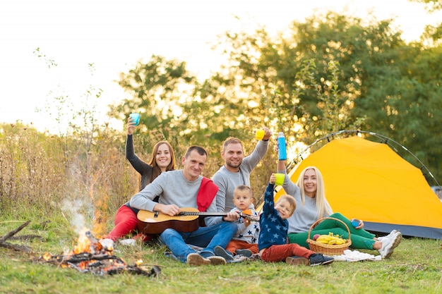 Grupo de amigos felices con carpa y bebidas