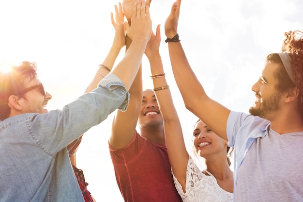 Grupo de amigos felices choca esos cinco y divirtiéndose juntos