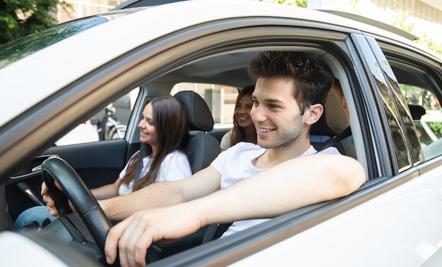 Grupo de amigos felices en un coche. Centrarse en el hombre