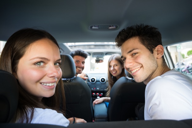 Grupo de amigos felices en un coche. Centrarse en el hombre