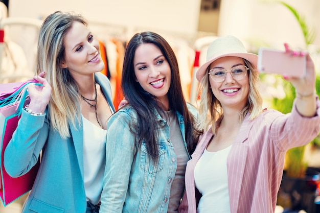 Grupo de amigos felices comprando ropa en el centro comercial