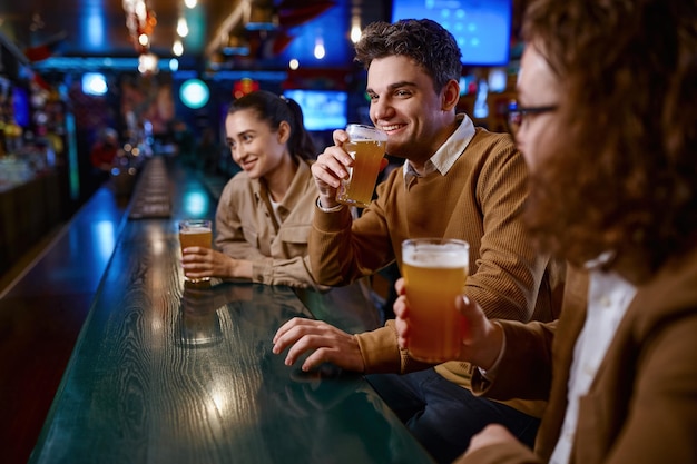 Grupo de amigos felices descansando y hablando en el bar