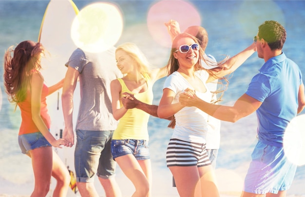 Grupo de amigos felices divirtiéndose juntos en la playa